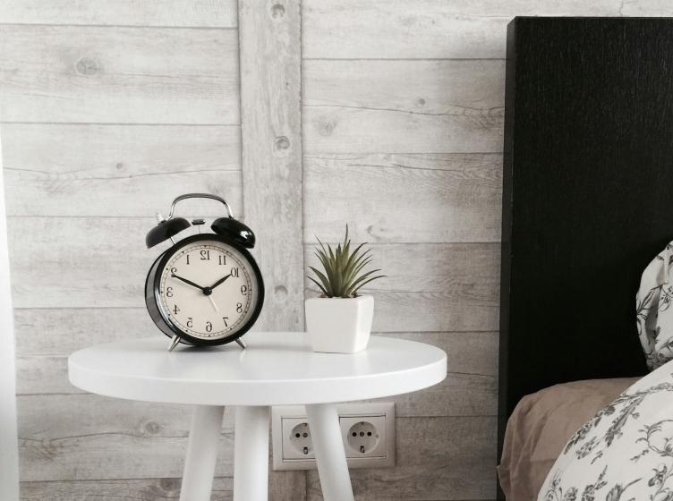 Analog alarm clock on bedside table